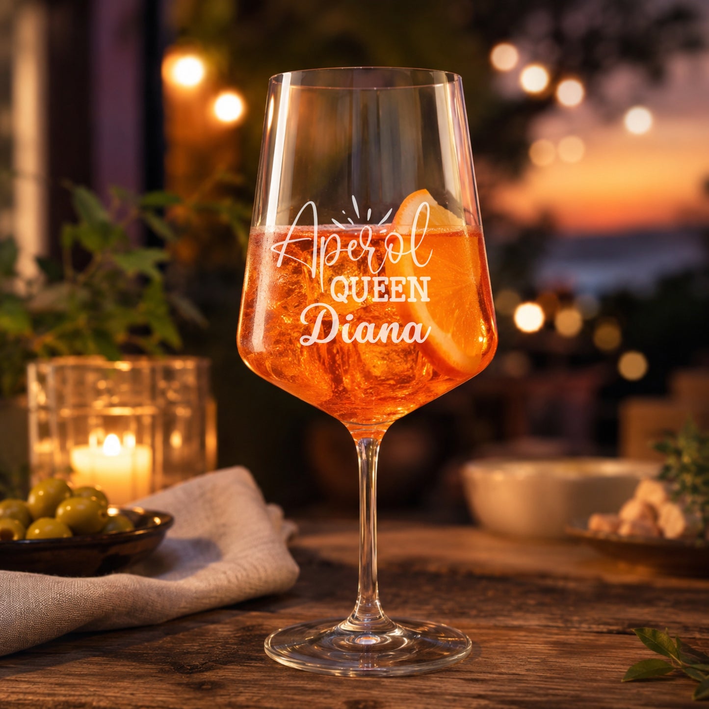 Personalisiertes Aperol Queen Glas mit Name Diana und Aperol Spritz in stimmungsvoller Abendatmosphäre