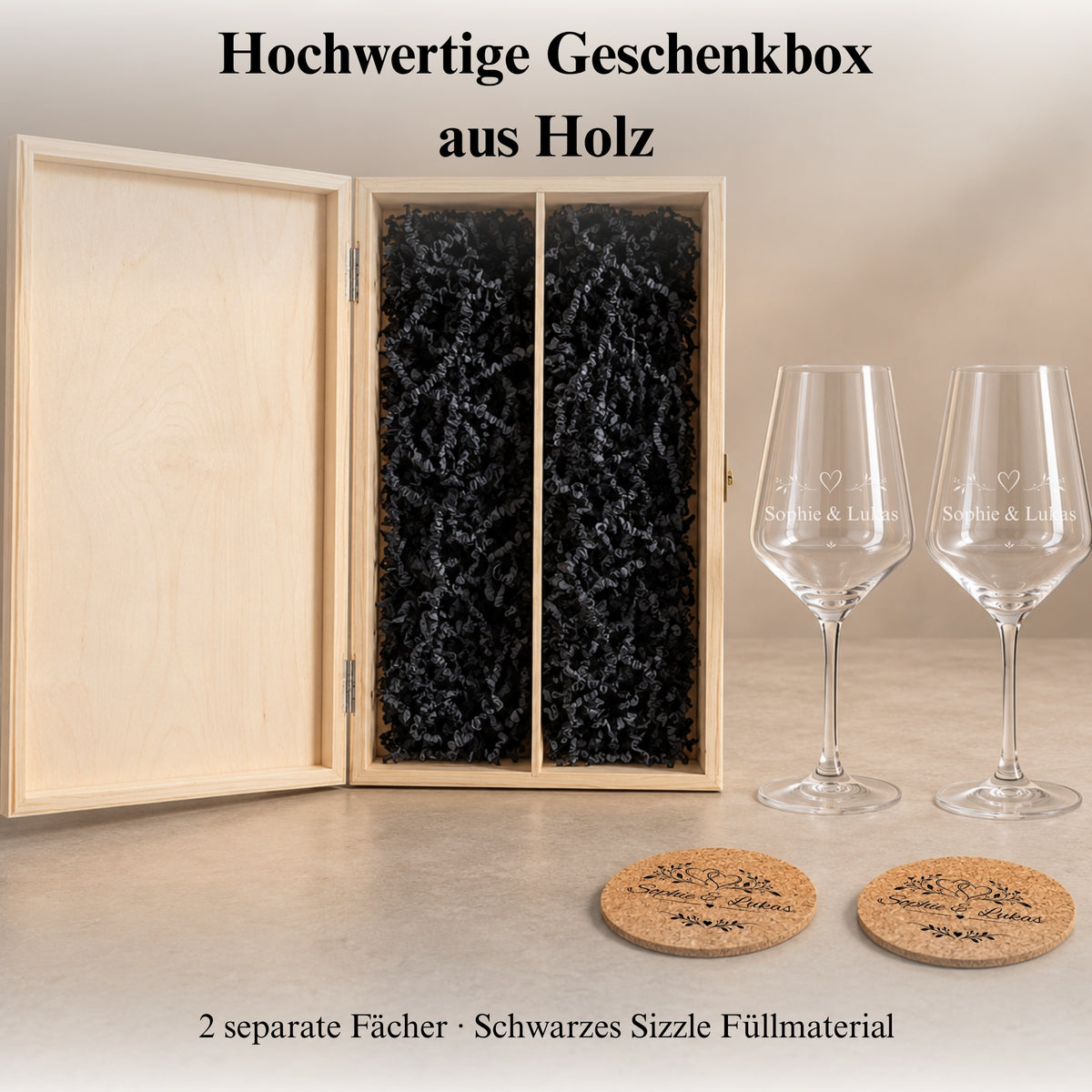 Geöffnete Holzgeschenkbox mit zwei Fächern und schwarzem Füllmaterial neben zwei Weingläsern und Korkuntersetzern.