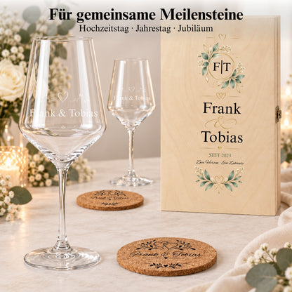 Personalisierte Weingläser und Korkuntersetzer mit Frank und Tobias neben einer Holzbox mit Namen und Datum.