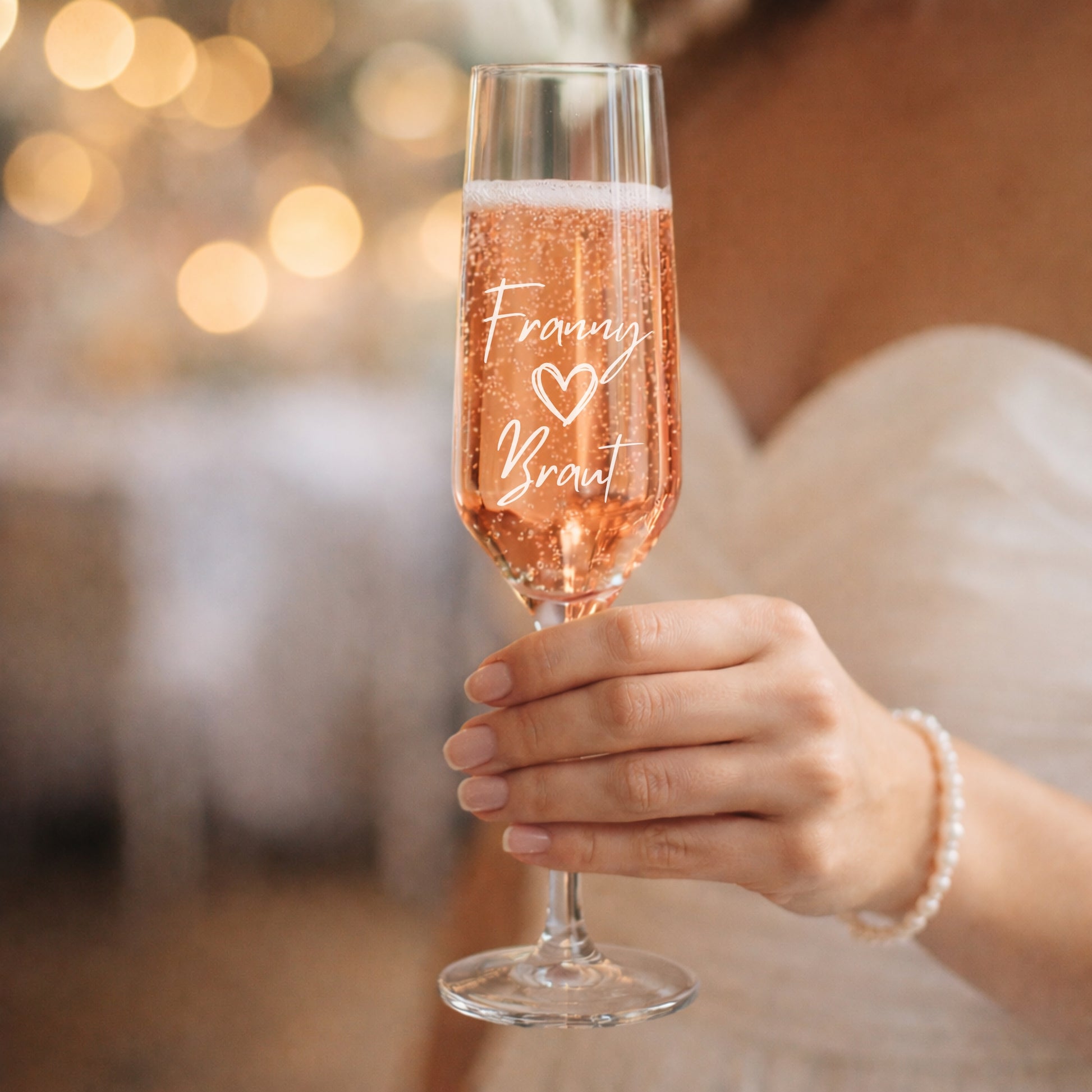 Personalisierte Sektgläser zur Hochzeit mit Gravur ‚Braut‘ in der Hand gehalten, elegantes Design